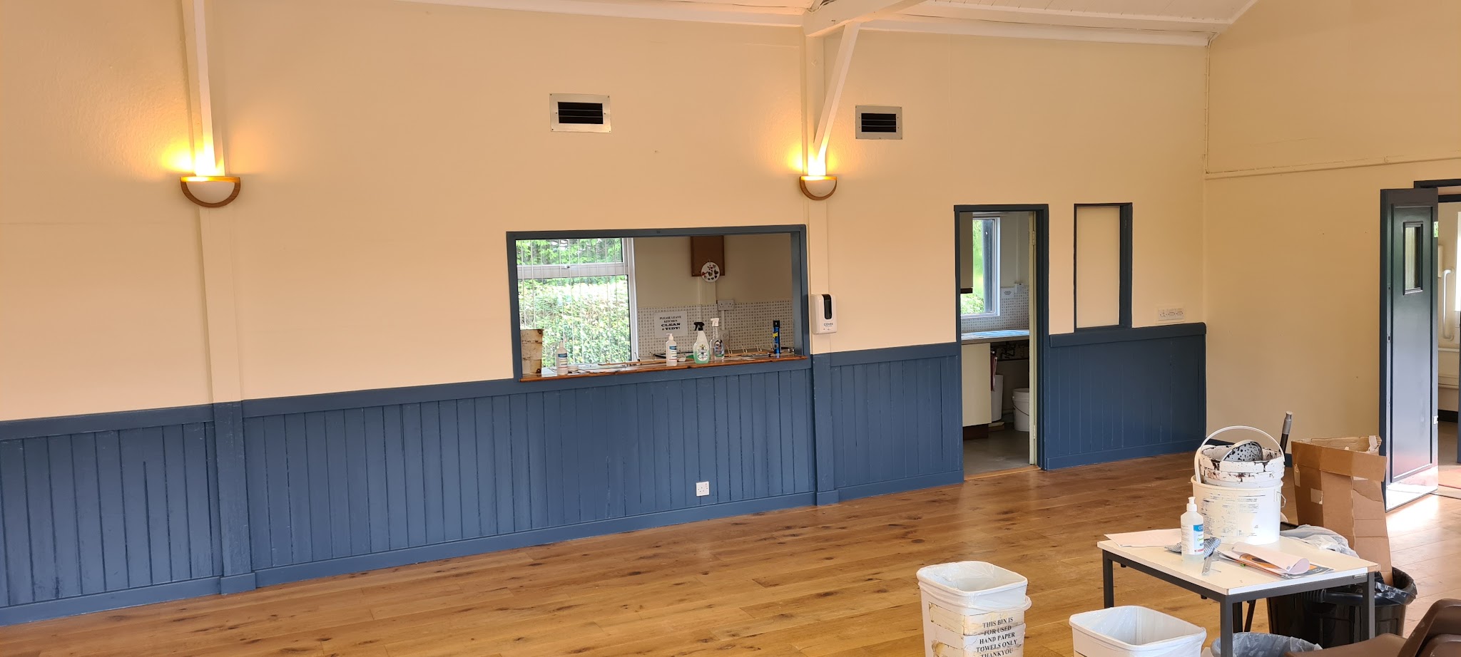 Hall interior mid-job, blue-grey panelling freshly painted below cream walls