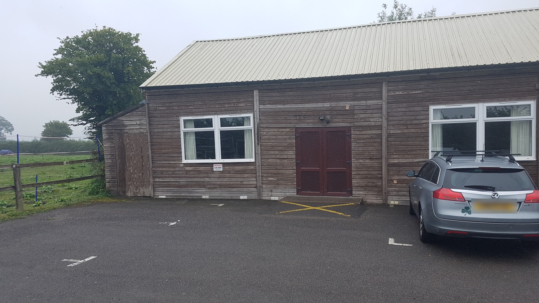 Timber-clad hall with painted white windows and maroon doors