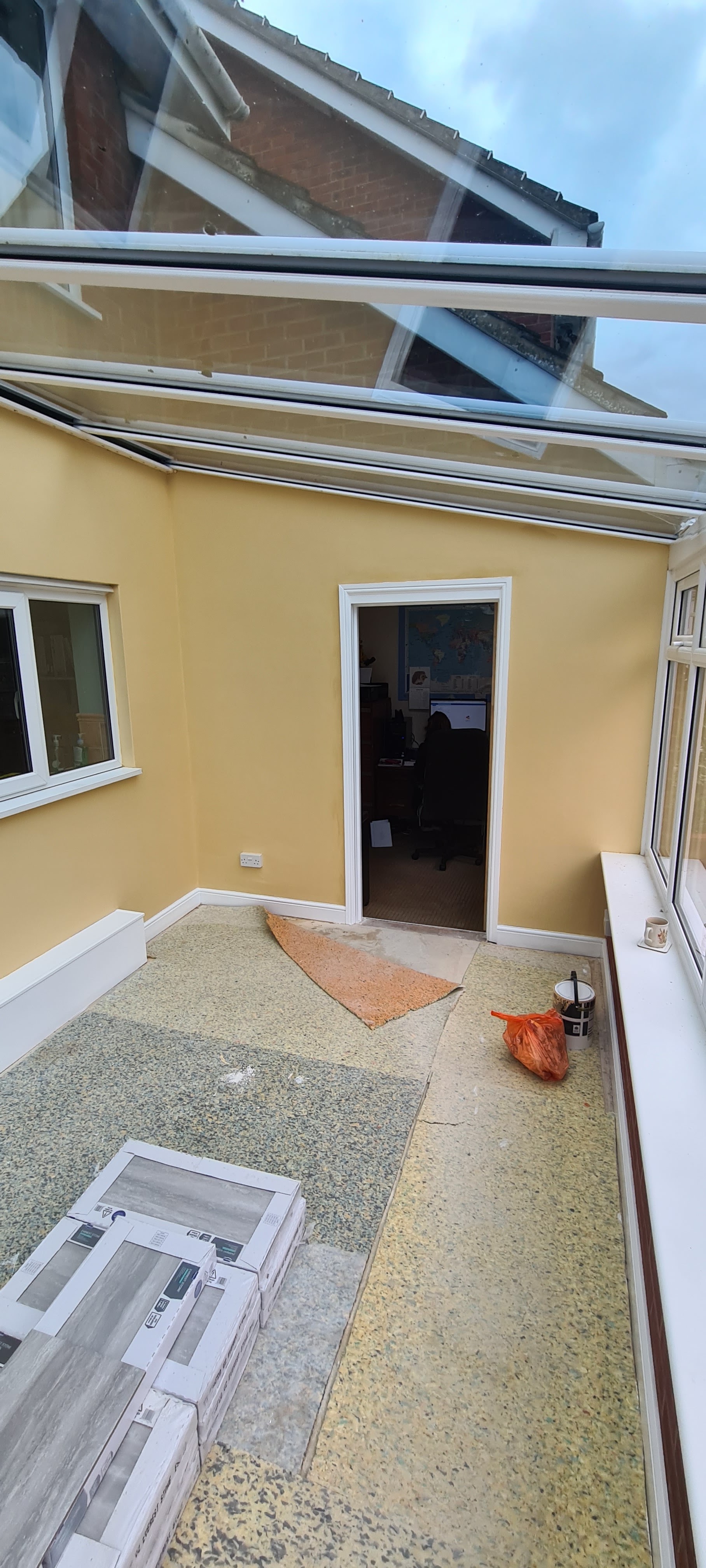 Pale yellow lightwell walls freshly painted, seen from above with a white door